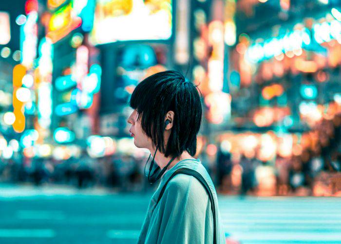 A young Japanese man with long hair by the famous Shibuya crossing.